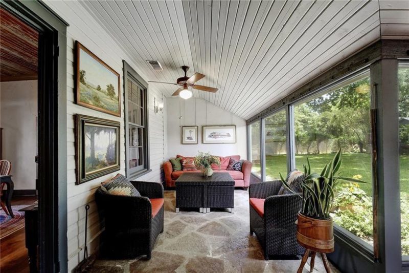 Sunroom with sloped ceiling and large windows