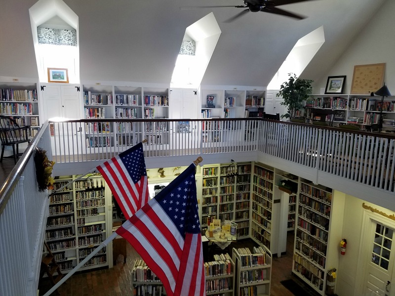 Inside Beach Haven Public Library with bookshelves and two American flags