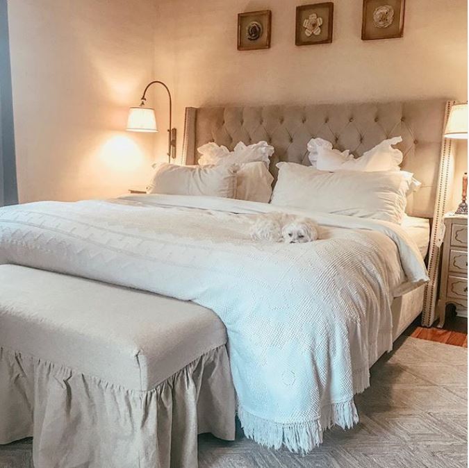 A bedroom with a large tufted bed