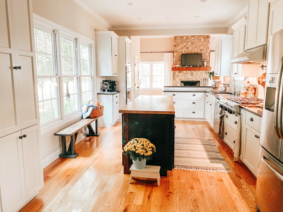 A kitchen with a wood floor and black island 