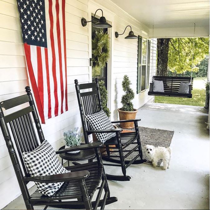 Front porch with flag, rocking chairs and swing