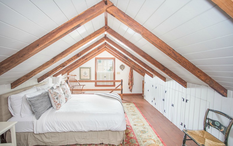 A bedroom with a bed and built-in storage wall