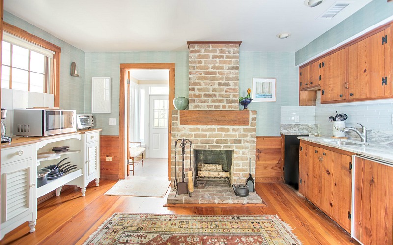 A kitchen with wooden cabinets and a fireplace