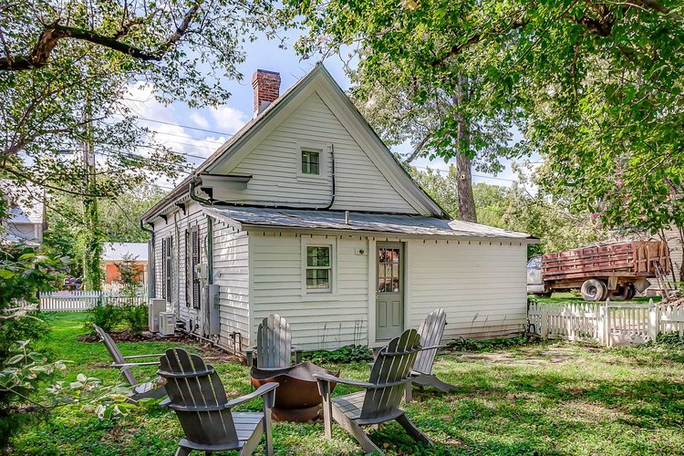 Backyard of Sweeney Cottage with Adirondack chairs around fire pit