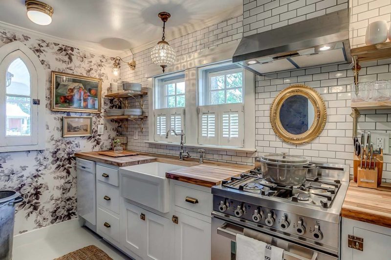 Cottage kitchen with white cabinets, butcher block countertops and subway tile