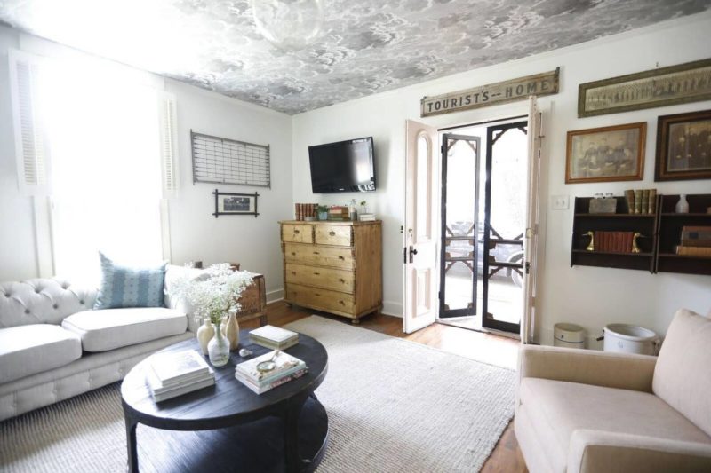 Living room with wallpapered ceiling and double entry doors open