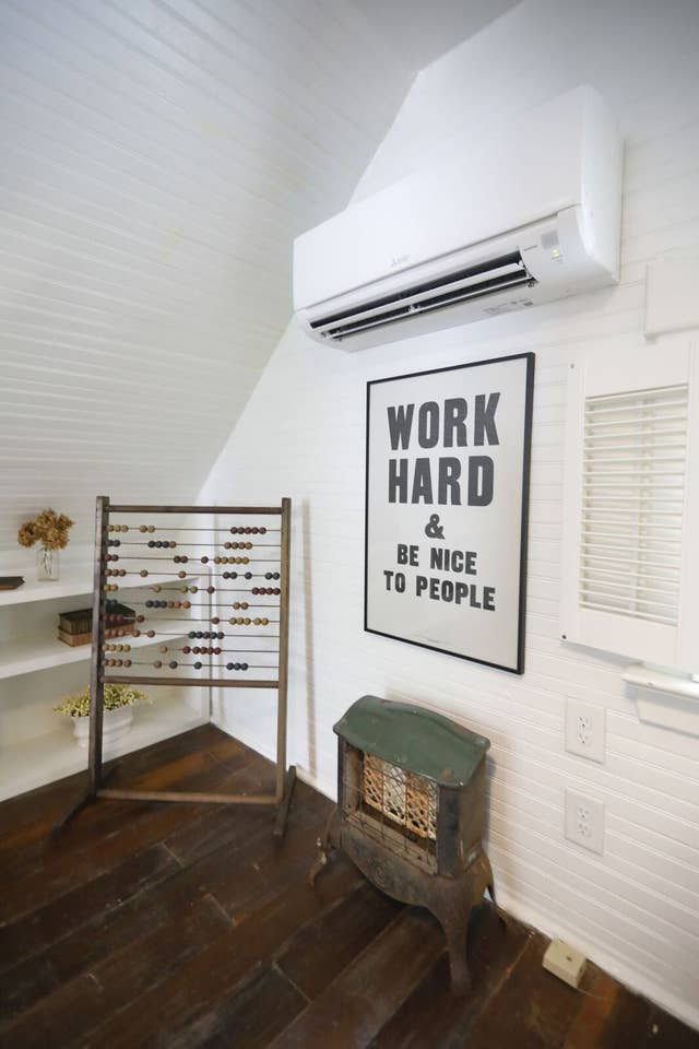 Bedroom with sign on wall \"Work Hard & Be Nice to People\"