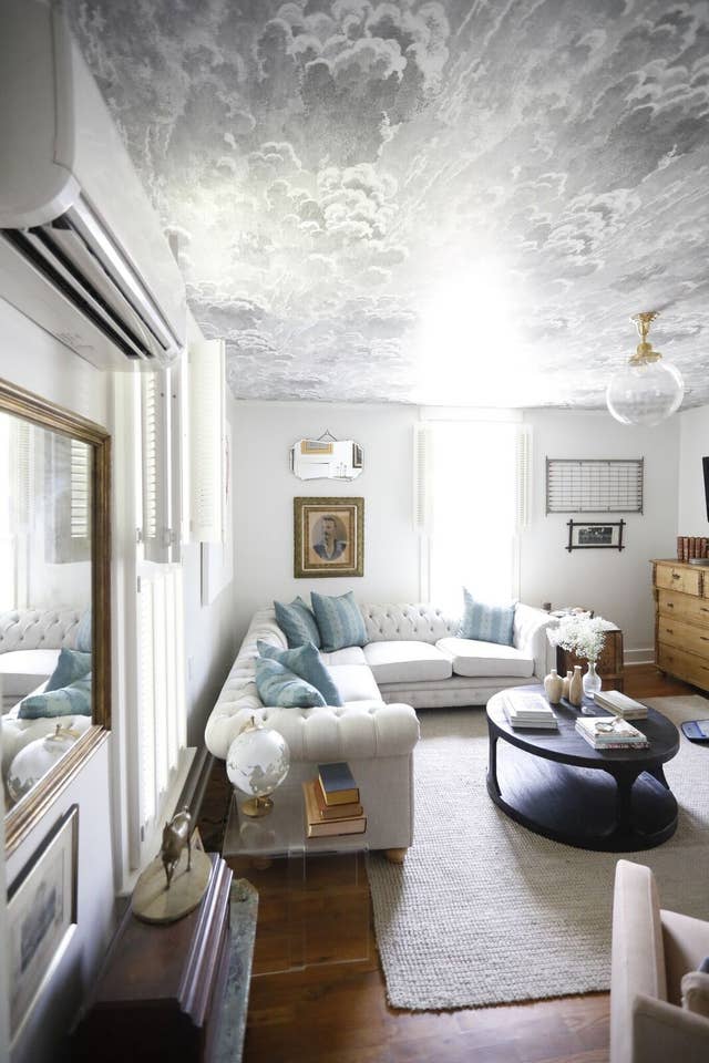 Cottage living room with sectional sofa and wallpapered ceiling