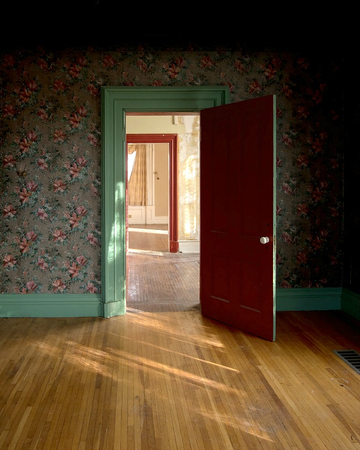 Bedroom door painted red with green trim