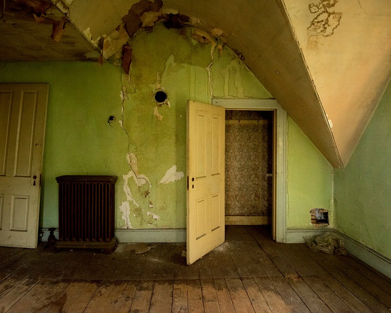 A close up of a door with crumbling plaster on wall