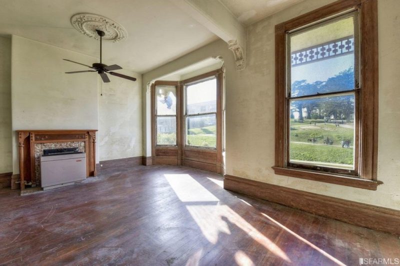 A large room with a fireplace and a large bay window