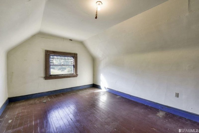 Empty attic room with window at top of house