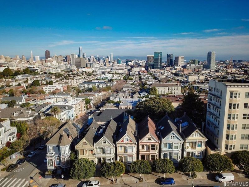 Aerial view of painted Victorians on Steiner with San Francisco in background