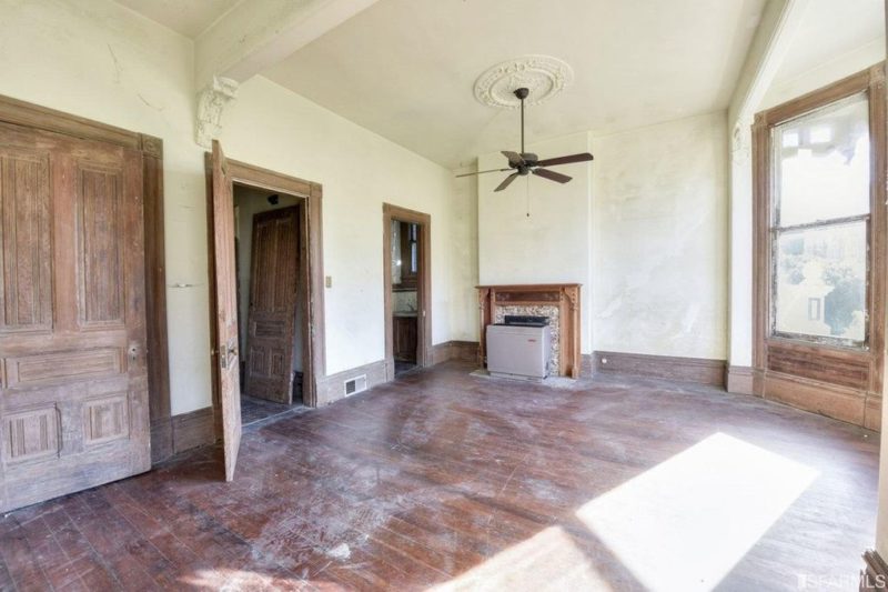 Empty room with fireplace and ceiling fan