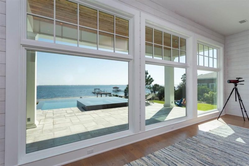 Large windows overlooking the pool and water