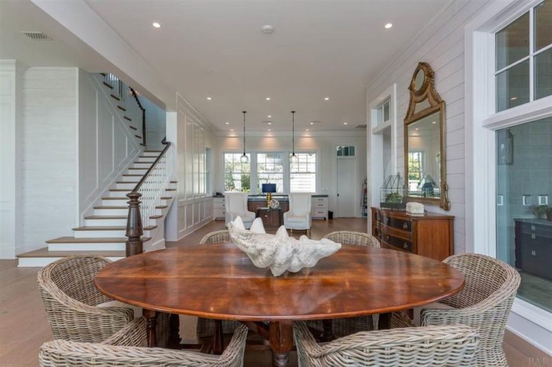 Dining table with wicker chairs and staircase