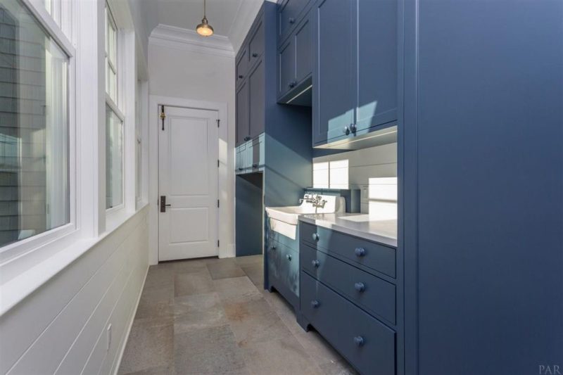 Walk-in kitchen pantry with blue cabinets and sink