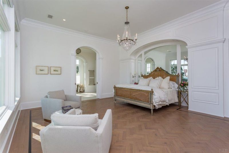 Master bedroom with white walls and herringbone wood floor