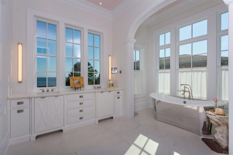 A bathroom with a large tub next to a window