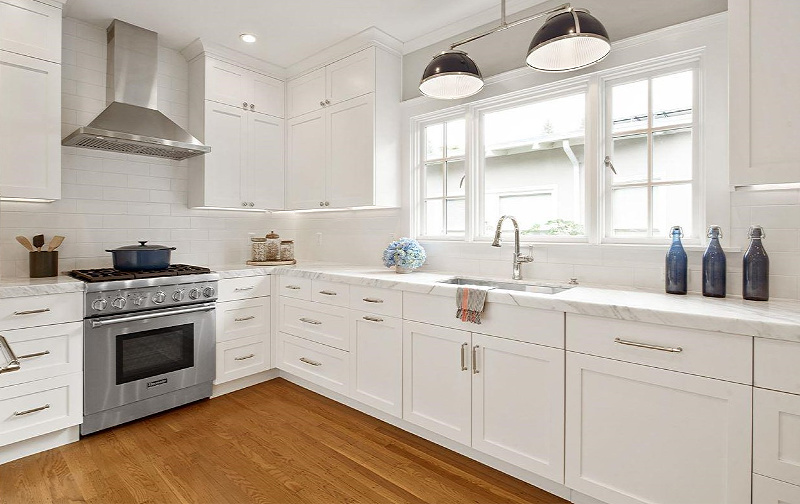 White kitchen with marble countertops and sink