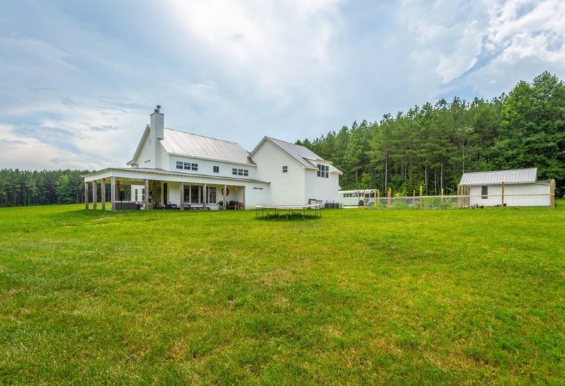 A large green field in front of a house