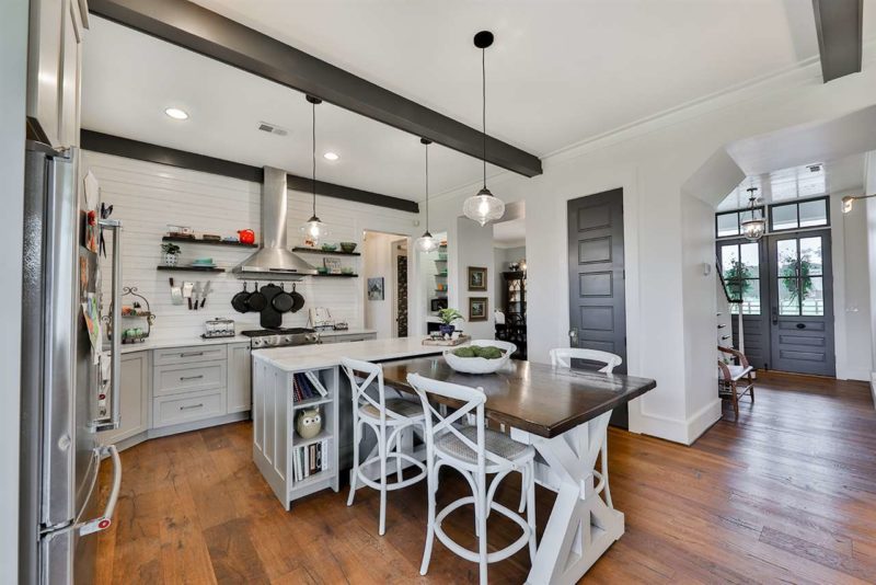 A kitchen with a hardwood floors and beamed ceiling