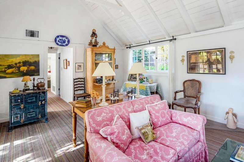 cottage living room with pink sofa and vaulted ceilings