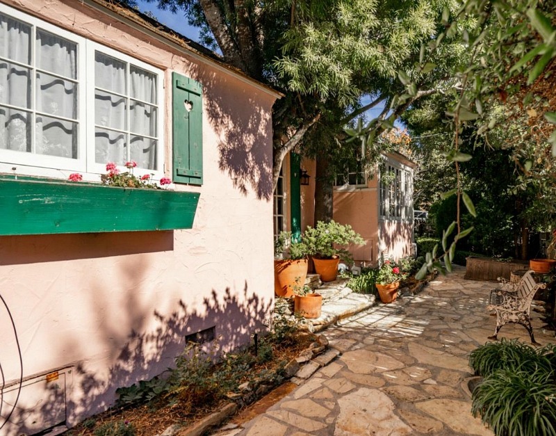 front of pink cottage with window boxes and shutters