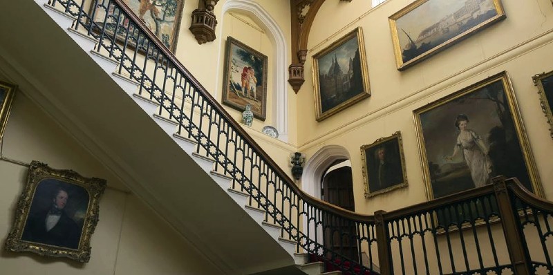 castle staircase with portraits